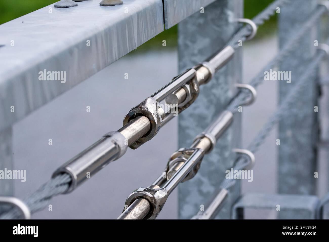 Tenditori che collegano le funi di sicurezza alla ringhiera sul ponte. Estate. Foto Stock