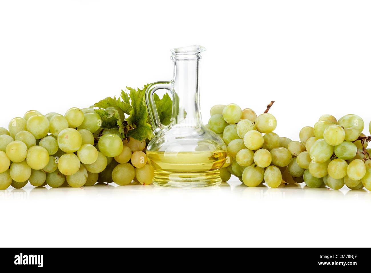 Olio di semi d'uva su fondo bianco. L'immagine mostra anche uva chiara e uva scura disposta su sfondo bianco Foto Stock