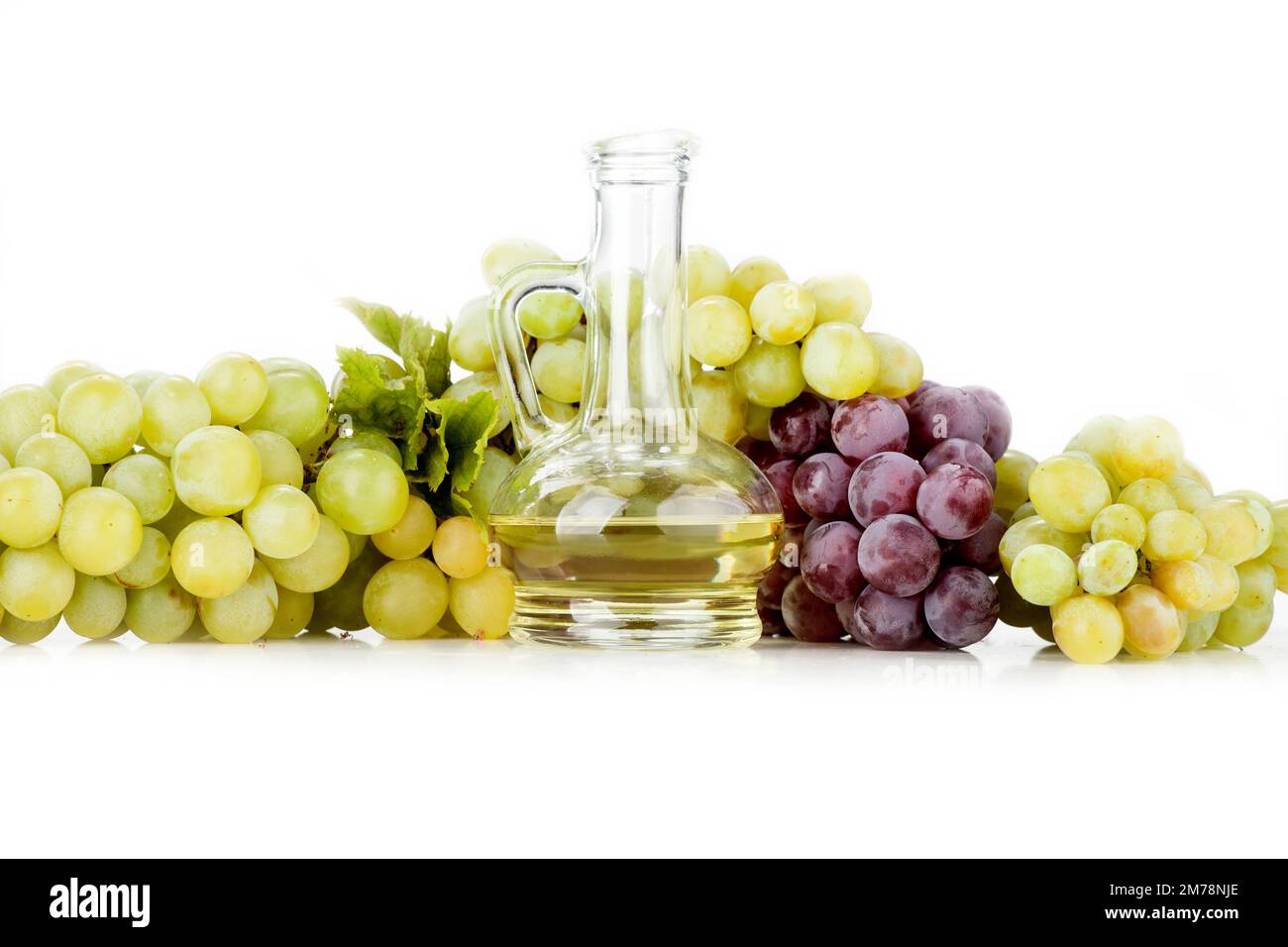 Olio di semi d'uva su fondo bianco. L'immagine mostra anche uva chiara e uva scura disposta su sfondo bianco Foto Stock