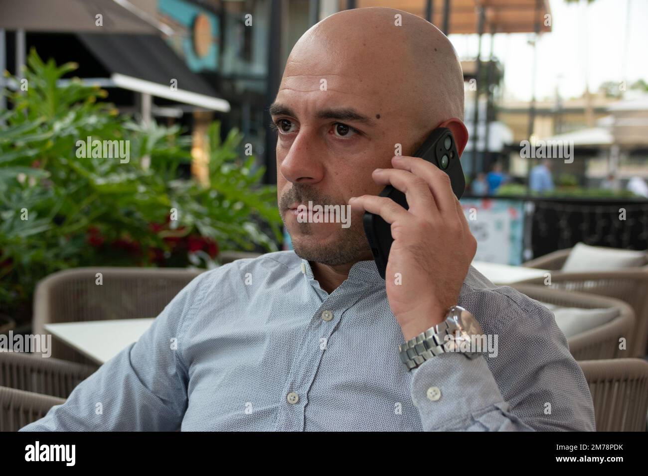 Bald uomo d'affari caucasico ottiene una telefonata con cattive notizie finanziarie Foto Stock