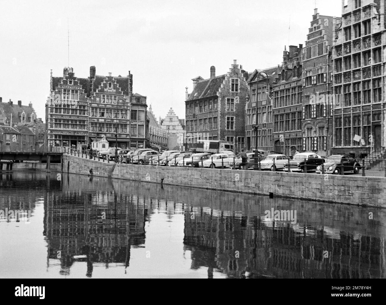 1960s Vista del Riverside Graslei Quay sul fiume Leie, con auto d'epoca 1950s-1960s parcheggiate sul molo (ora zona pedonale) nella Città Vecchia o nel quartiere storico di Gand Belgio c1960. Fotografia vintage in bianco e nero o monocromatica. Foto Stock