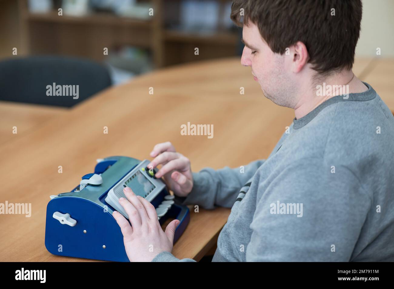 Uomo cieco che usa la macchina da scrivere braille. Foto Stock