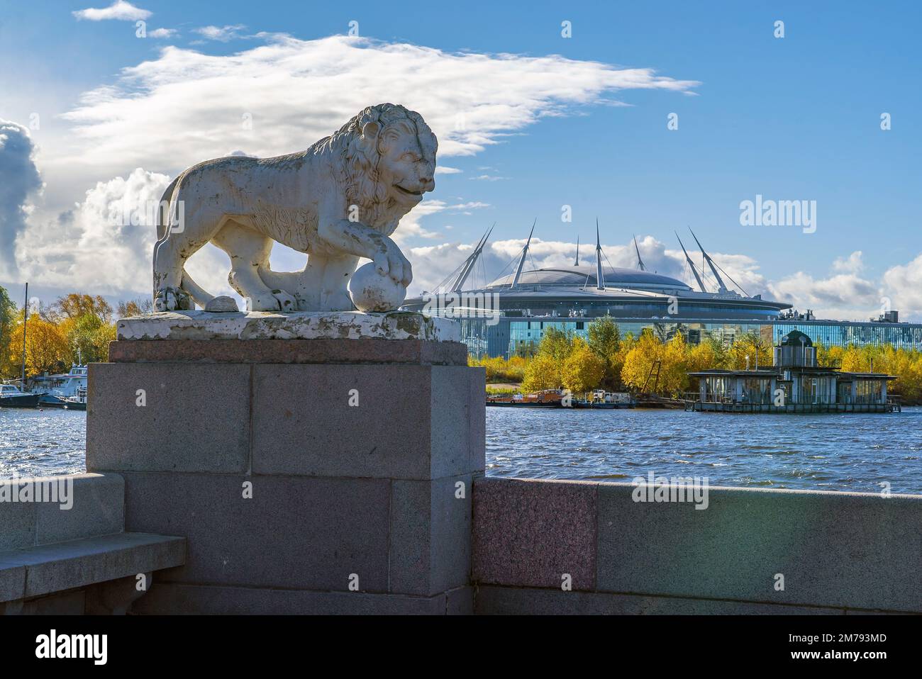 Scultura di un leone con una palla sullo sfondo dell'edificio Zenit Arena. Isola di Elagin. San Pietroburgo Foto Stock