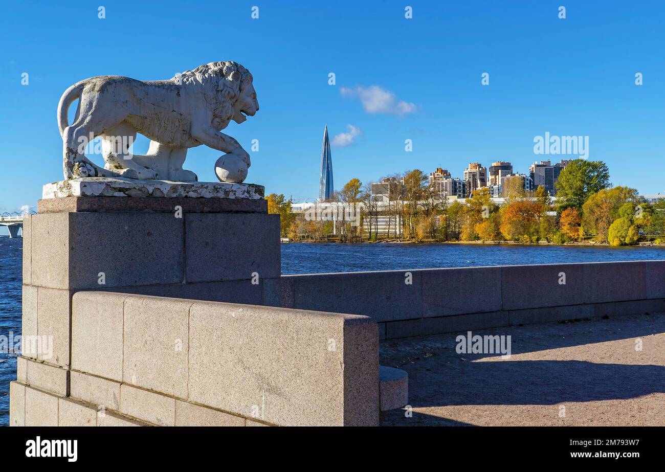 La scultura di un leone con una palla sullo sfondo dell'edificio Lakhta center. Isola Elagin. Saint Petersburg Foto Stock