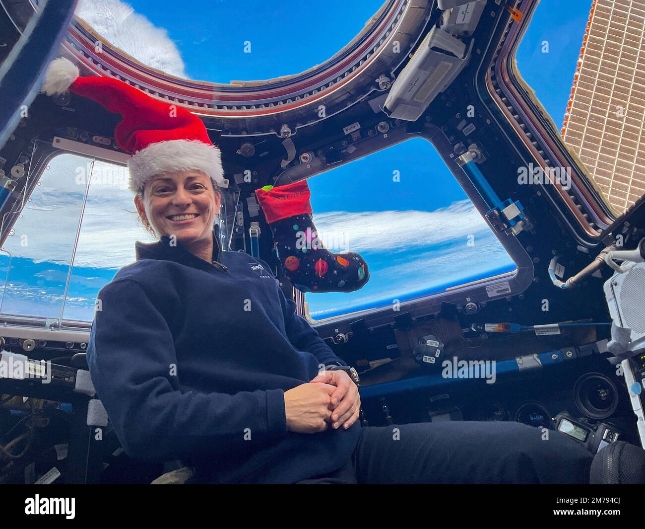 Stazione spaziale Internazionale, ORBITA TERRESTRE. 24 dicembre 2022. NASA Expedition 68 Nicole Mann, ingegnere di volo della NASA, posa per un ritratto di festa con la sua calza di Natale la vigilia di Natale all'interno della cupola della Stazione spaziale Internazionale, 25 dicembre 2022 in Earth Orbit. Mann, è il primo astronauta dei nativi americani nello spazio e il primo a comandare una missione. Foto Stock