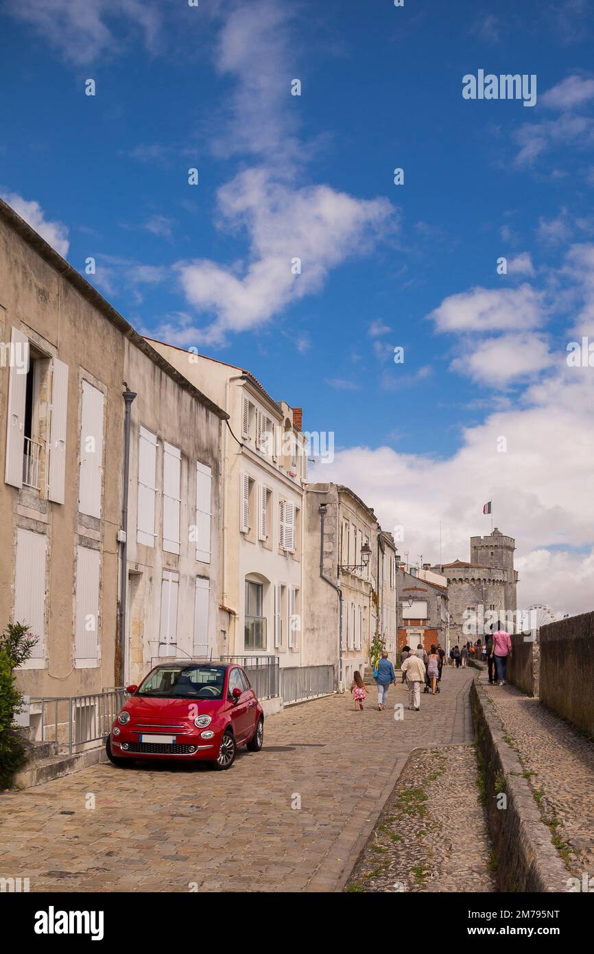 L'auto rossa è parcheggiata su una strada acciottolata in una zona visitata dai turisti dalla città portuale francese di la Rochelle. Foto Stock