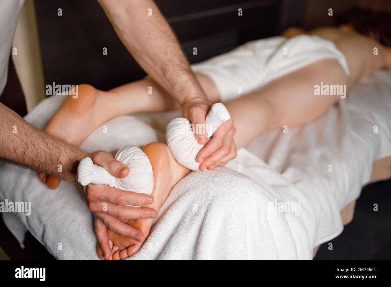 Massaggio plantare con bustine di erbe Foto Stock
