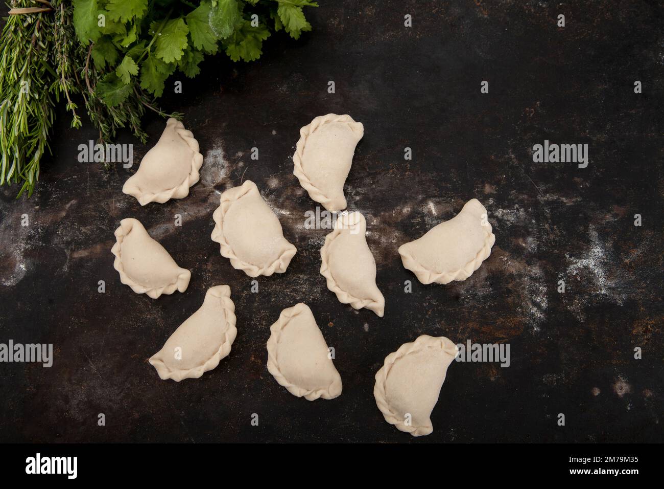 Gnocchi fatti a mano in casa su uno sfondo rustico insieme alle erbe Foto Stock