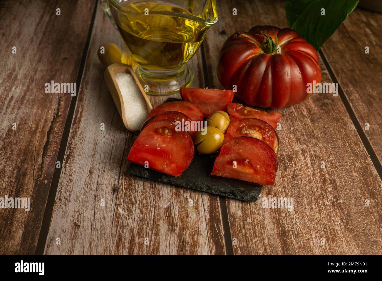 Pomodori moreschi tritati con vasetto di olio d'oliva e cucchiaio di legno con sale Foto Stock