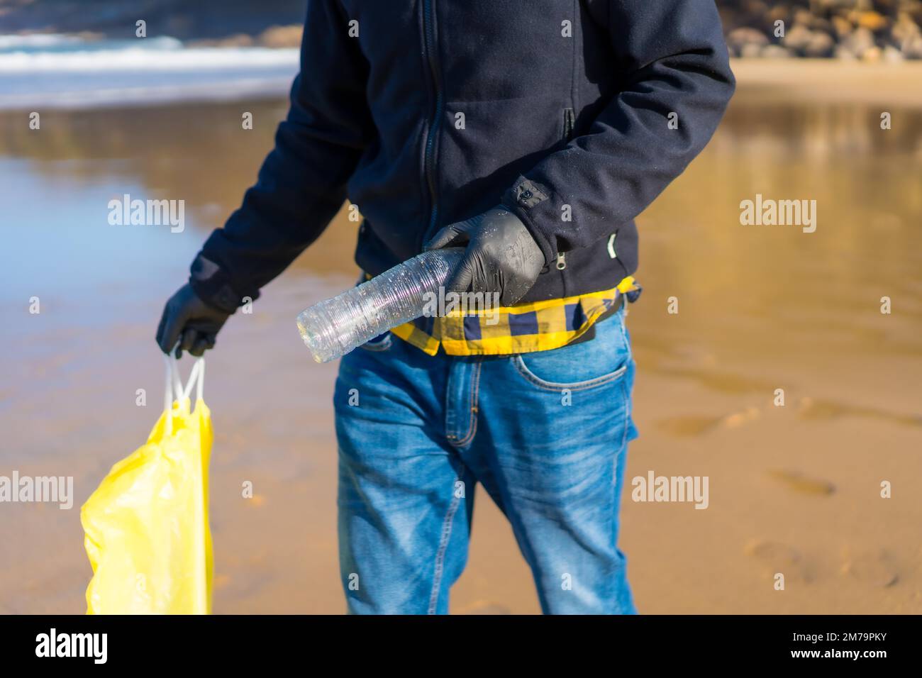 Inquinamento marino, volontario irriconoscibile che raccoglie plastica sulla spiaggia. concetto di ecologia Foto Stock