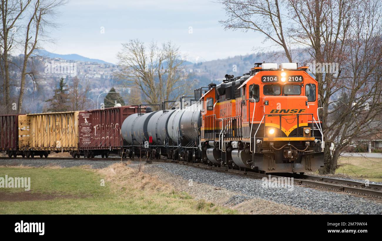 Sumas. WA. USA - 5 gennaio 2023; treno BNSF con carico su pista singola in inverno con fari Foto Stock