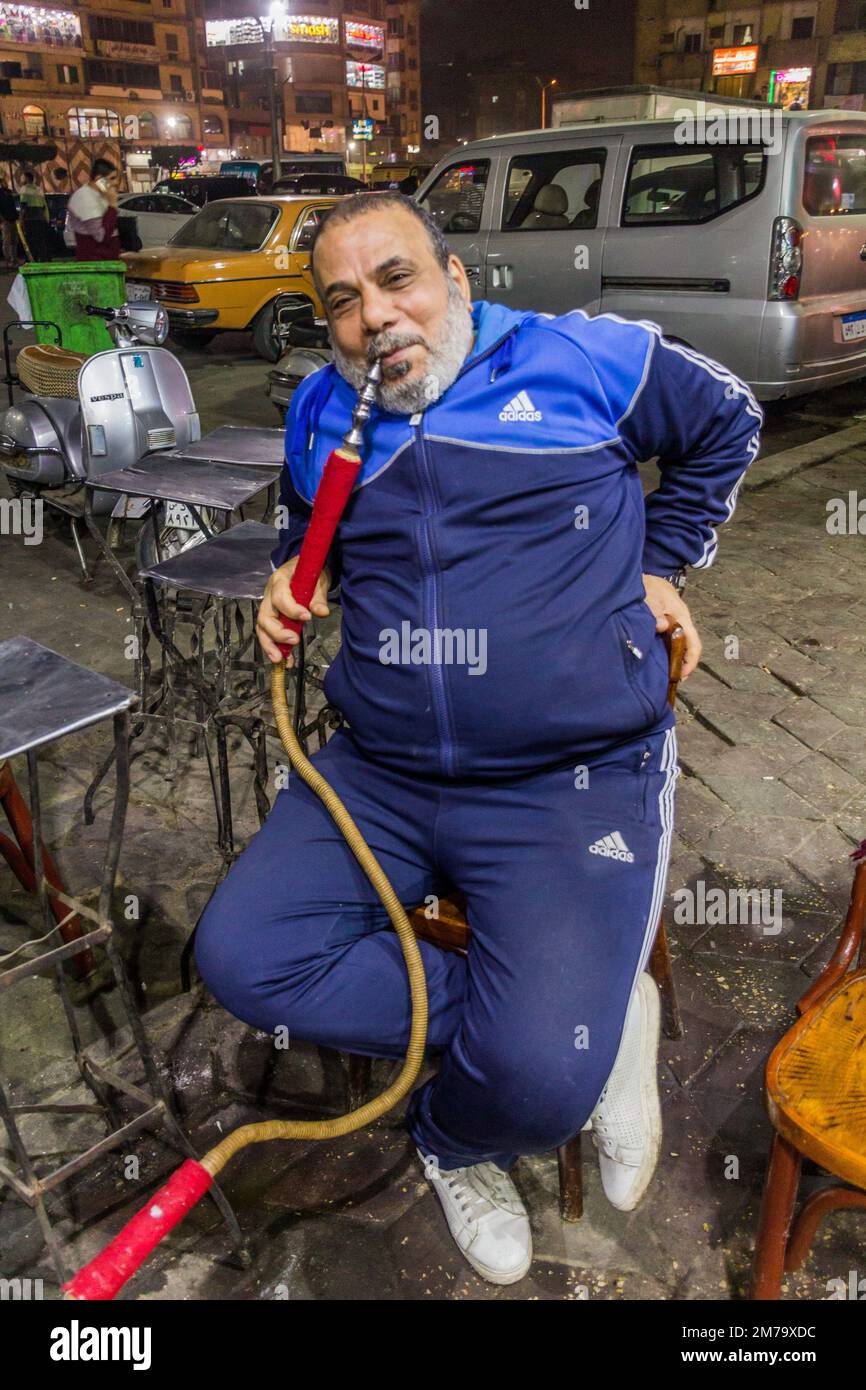 CAIRO, EGITTO - 26 GENNAIO 2019: L'uomo locale che fuma una pipa d'acqua in un caffè di strada tradizionale al Cairo, Egitto Foto Stock