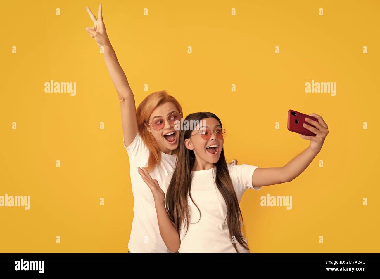 felice successo donna madre e bambina facendo selfie su smartphone, successo Foto Stock