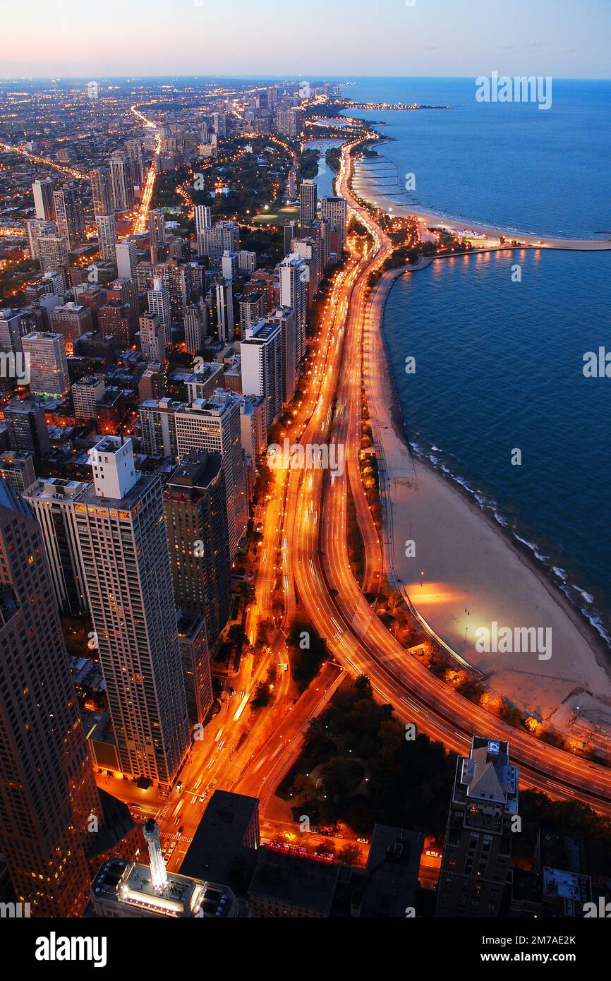 Il traffico illumina Lake Shore Drive mentre viaggia sul lato nord di Chicago al tramonto Foto Stock