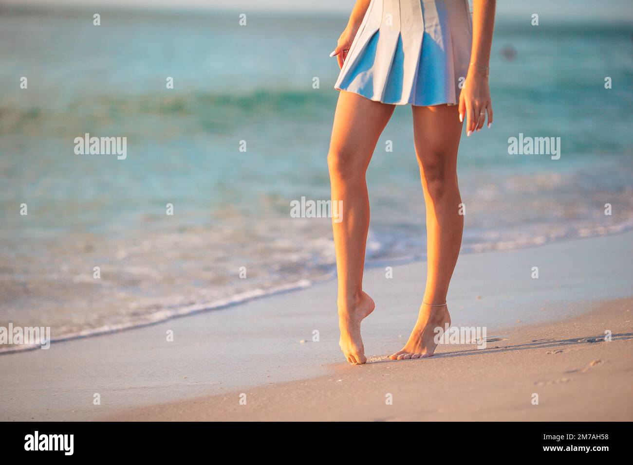 Gambe femminili sul primo piano della spiaggia. Ragazza che cammina sulla spiaggia Foto Stock