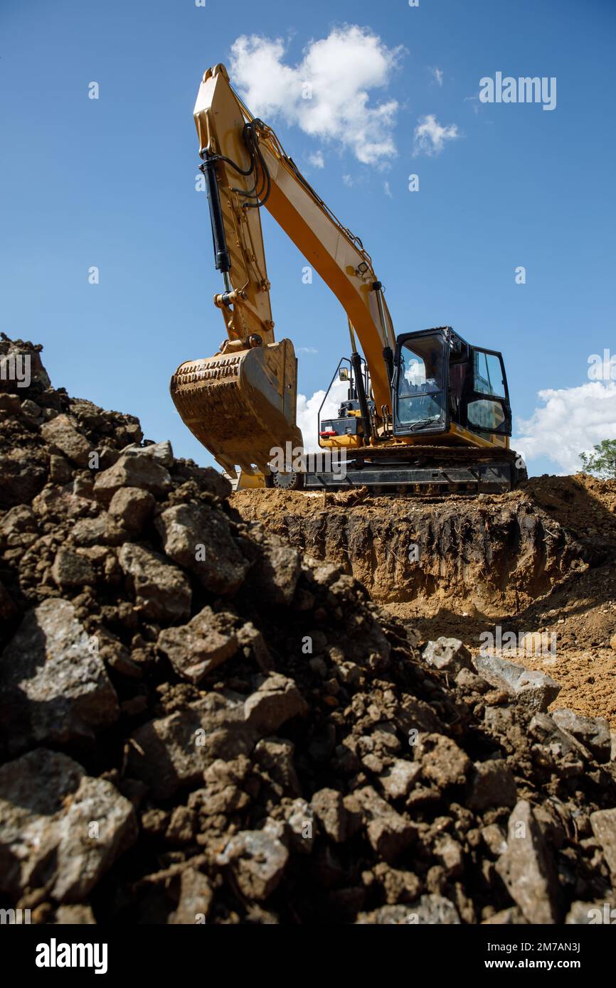 Un grande escavatore da costruzione di colore giallo sul cantiere in cava per l'estrazione. Immagine industriale. Foto Stock