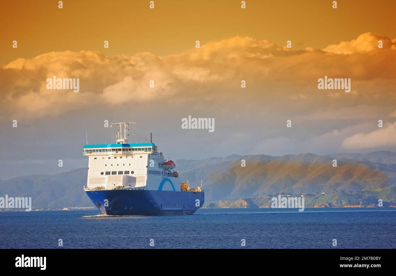 Una foto di nave, tramonto, oceano e montagne Foto Stock