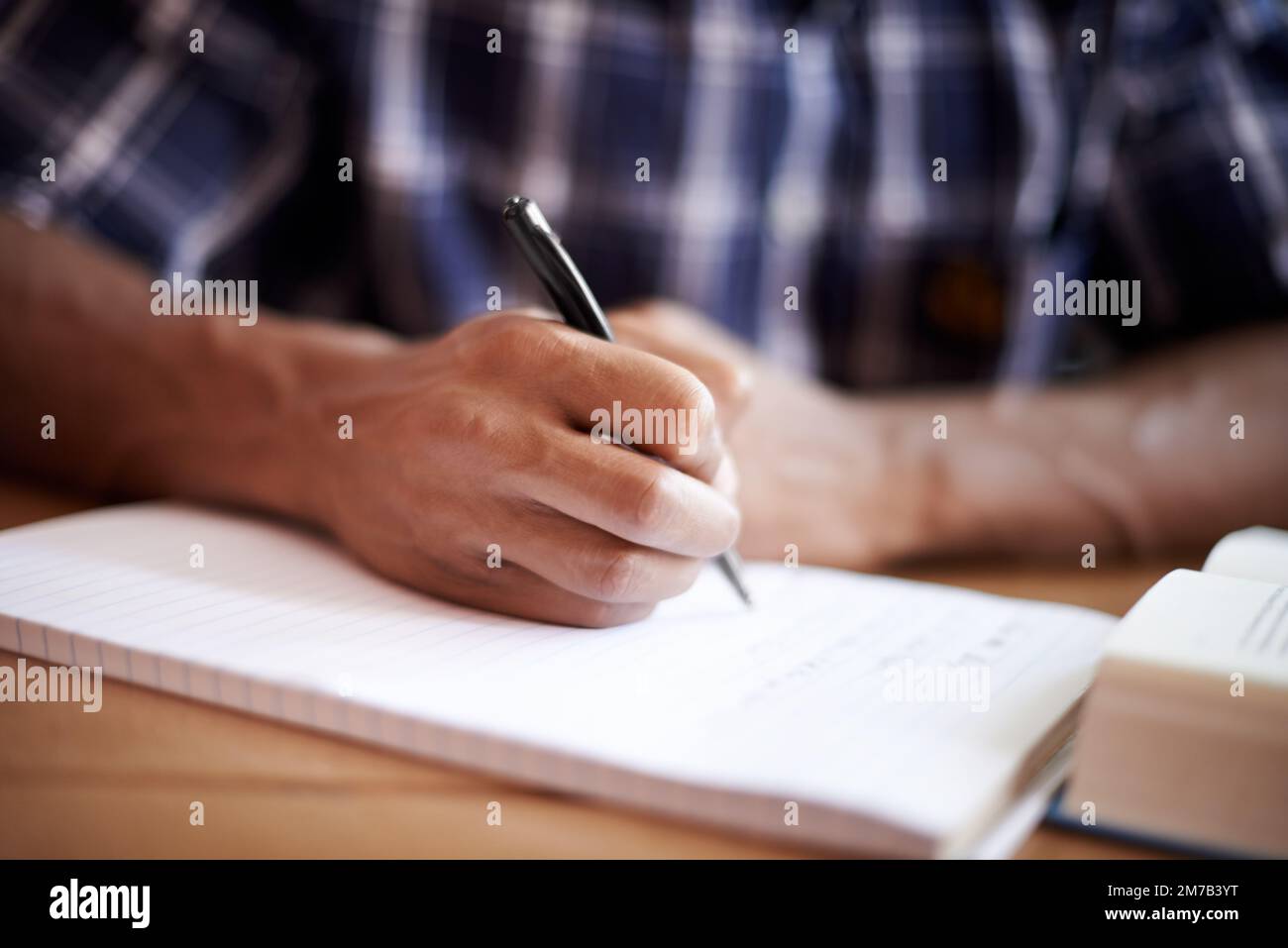 Le note buone sono la chiave per ottenere buoni risultati. Primo piano di un giovane studente che scrive su un blocco note. Foto Stock