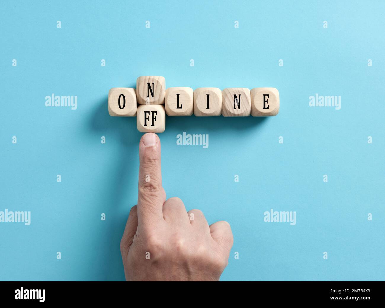 Non in linea. Per scegliere tra online e offline. Detox digitale. La mano maschile trasforma la parola online in offline su cubi di legno. Foto Stock