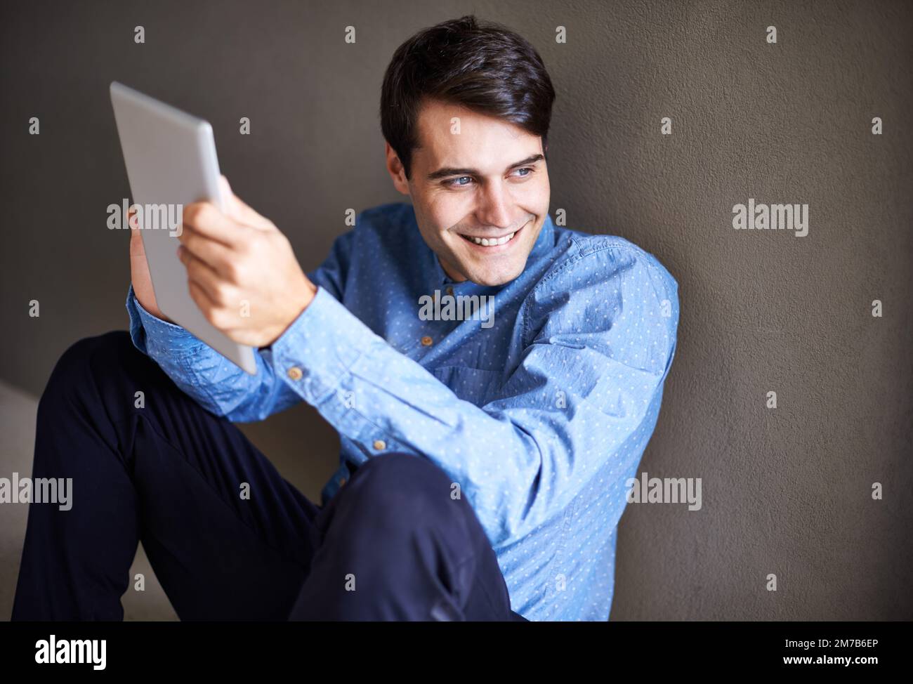 Ha grandi sogni per la sua attività. un giovane uomo d'affari sorridente seduto con il suo tablet digitale. Foto Stock