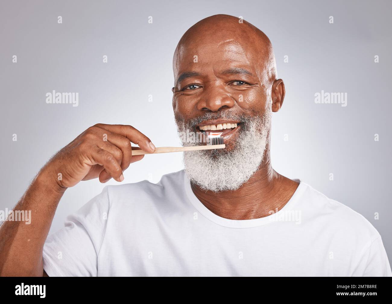 Denti spazzolanti, ritratto in studio e uomo nero con spazzolino per il benessere dentale maturo, stile di vita sano o pulizia estetica in Nigeria. Felice Foto Stock