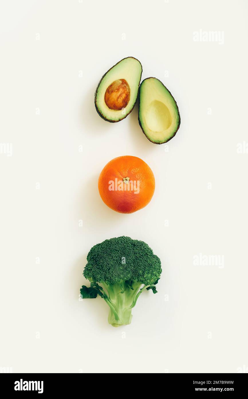 Avocado e broccoli su sfondo chiaro, vista dall'alto. Concetto di dieta di detox. Sfondo di verdure verdi Foto Stock