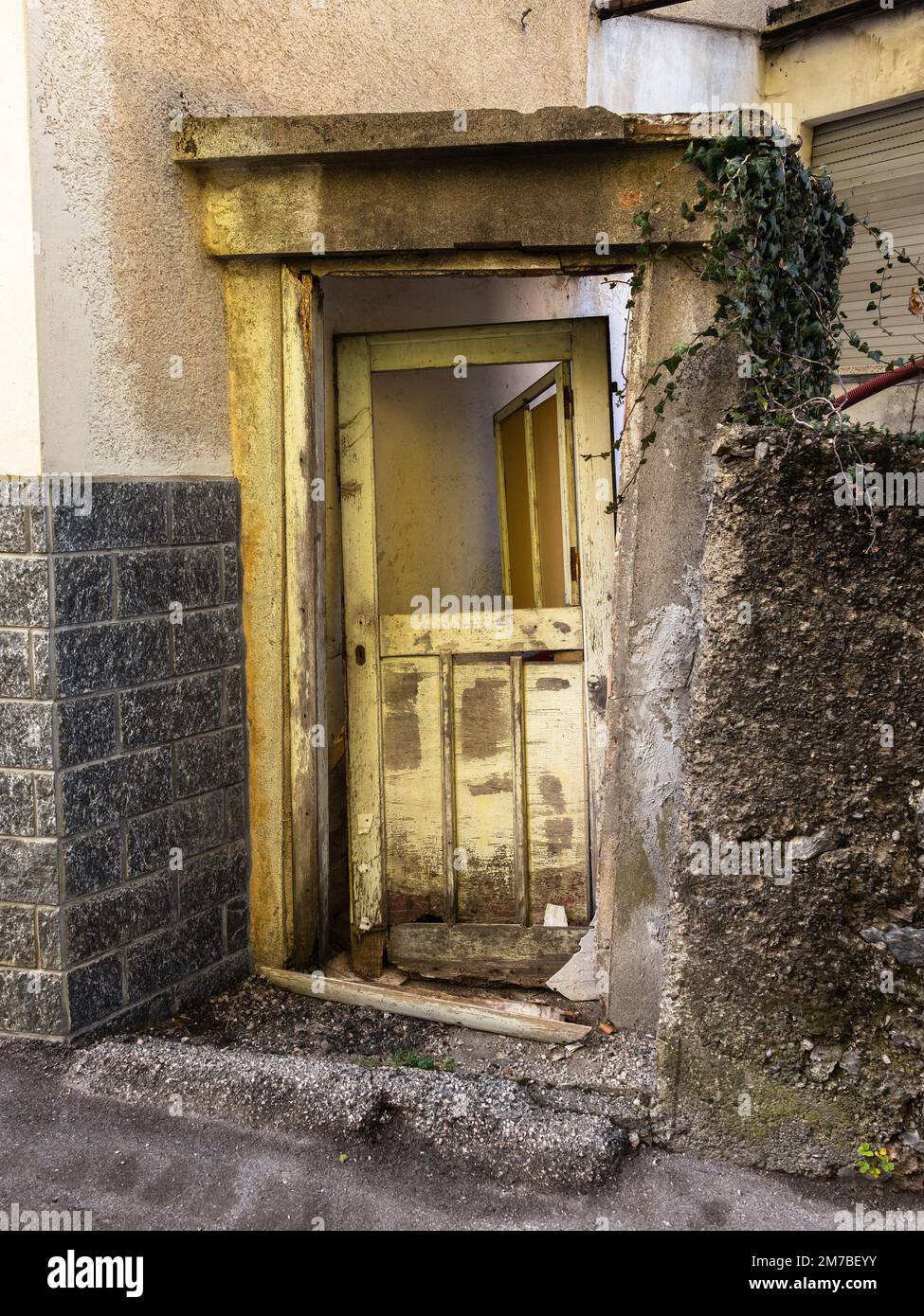 Rotta vecchia porta di una casa abbandonata nel villaggio di Sutrio, Italia Foto Stock