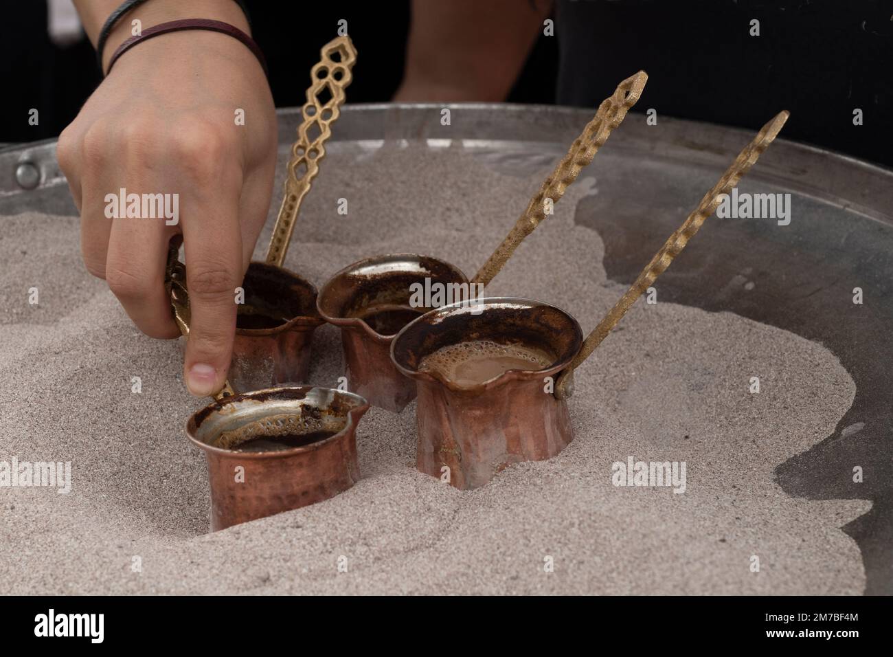 Il caffè turco è posto in sabbia calda per la preparazione. Un metodo tradizionale di preparazione del caffè in Turchia. Foto Stock