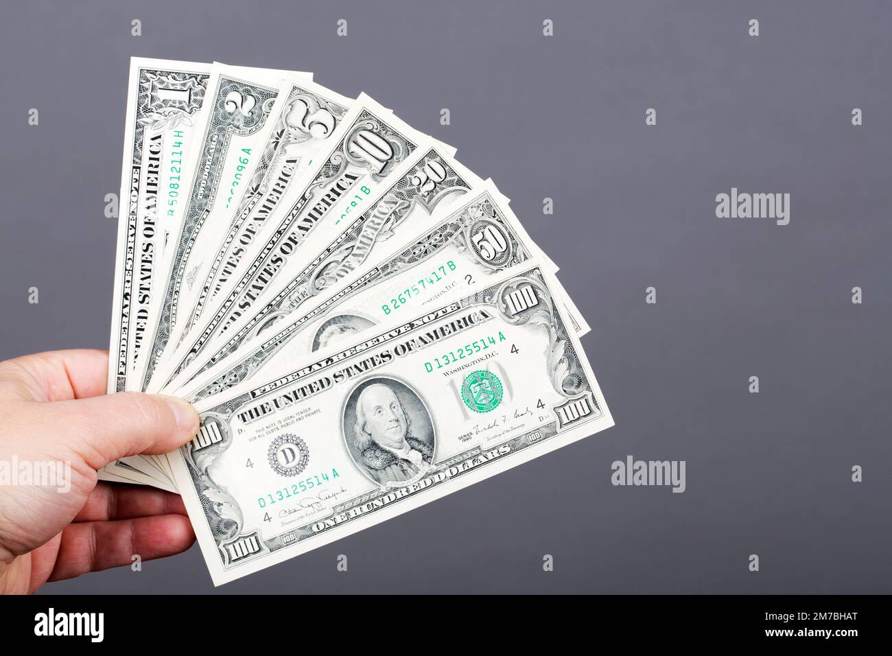 Vecchi soldi dagli Stati Uniti - dollari in mano su uno sfondo grigio Foto Stock