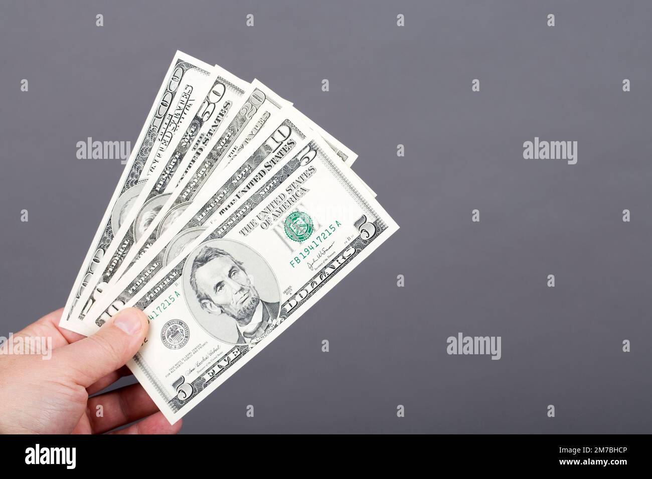 Vecchi soldi dagli Stati Uniti - dollari in mano su uno sfondo grigio Foto Stock
