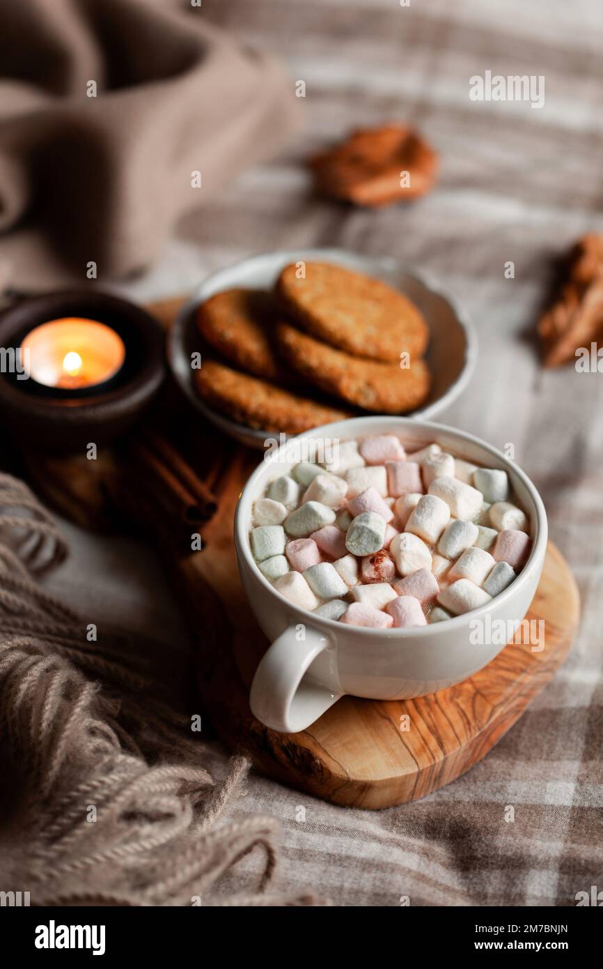 calda camera accogliente inverno o autunno concetto, tazza di cioccolata calda sul vassoio, candele lancio Foto Stock
