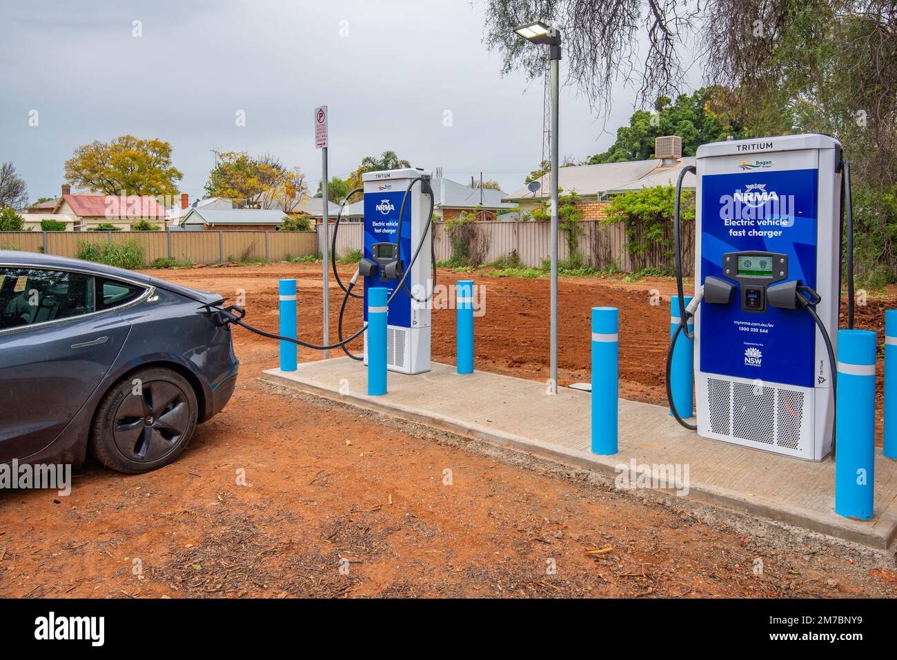 Un'auto si carica presso una stazione di carica della batteria del veicolo elettrico (EV) al trizio NRMA in un parcheggio a Nyngan, nel nuovo Galles del Sud occidentale, Australia Foto Stock