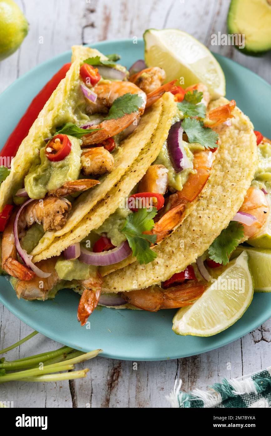 Tacos messicani con gamberi, guacamole e verdure su tavola di legno Foto  stock - Alamy