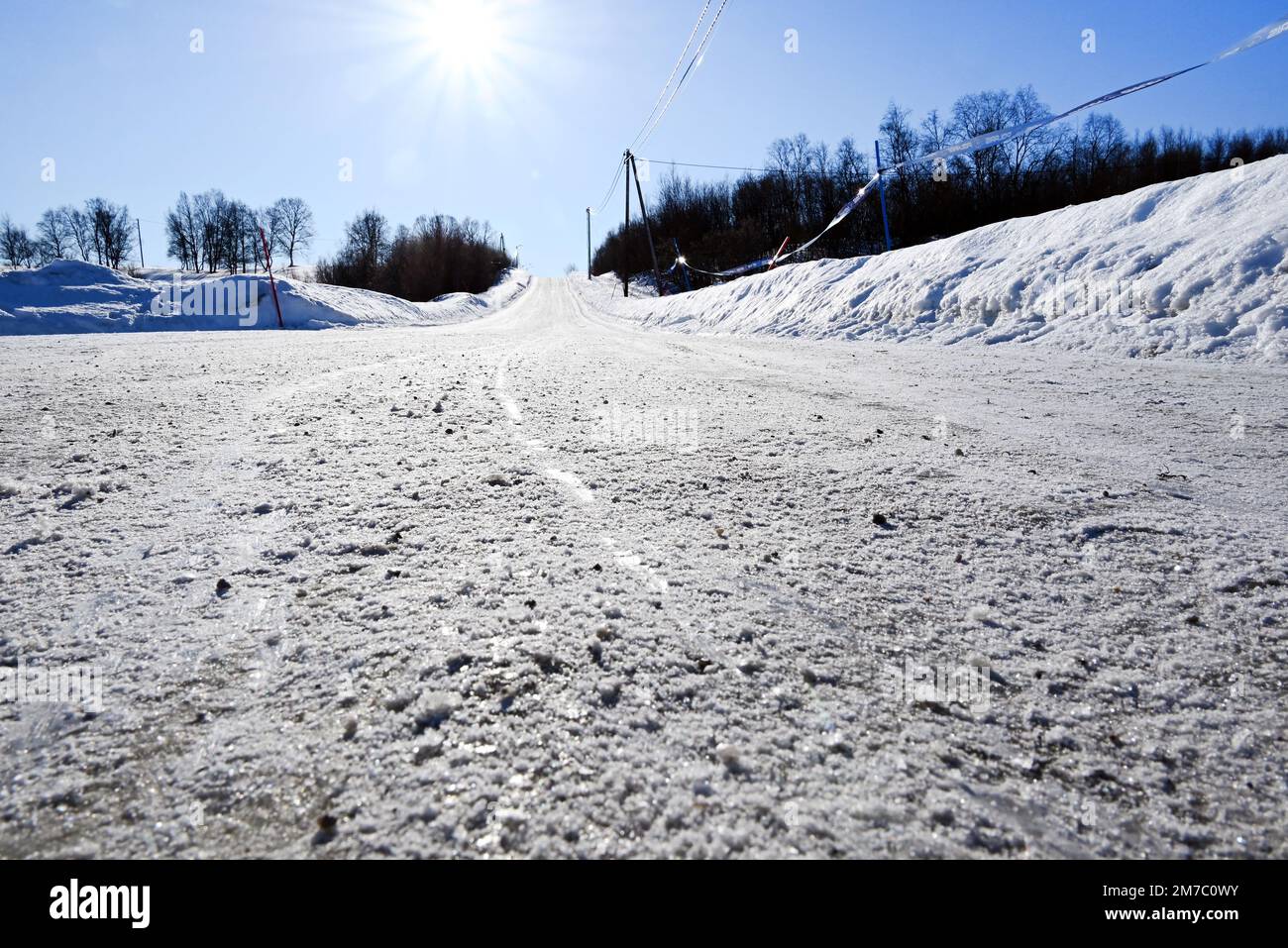 Una strada vuota scivolosa coperta di neve vicino a Kirkenes, nell'estremo nord della Norvegia, a Neiden. Foto Stock