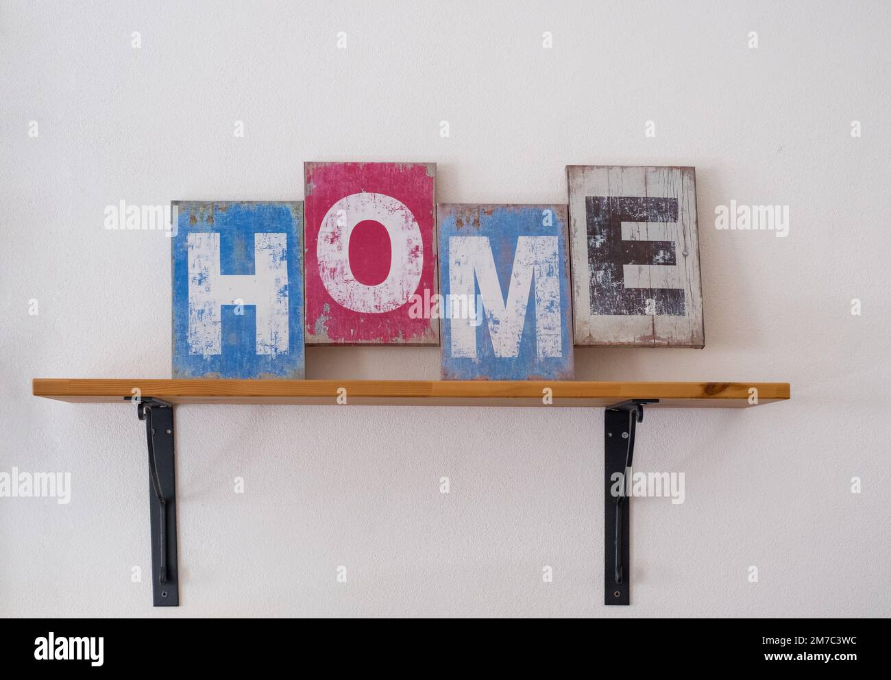 Scritta decorativa in legno 'Home' appesa su una parete bianca sullo  scaffale. Interno domestico, copy-spazio. Concetto di casa Foto stock -  Alamy