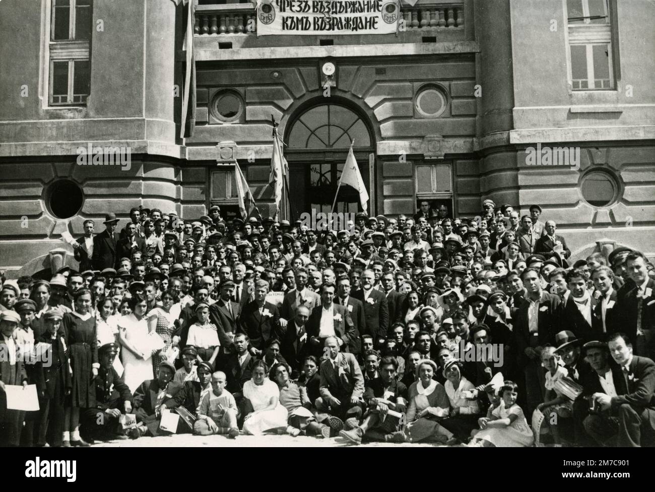 Grande gruppo di persone con il segno ATTRAVERSO LA RESISTENZA AL RISVEGLIO, Bulgaria, 1920s Foto Stock