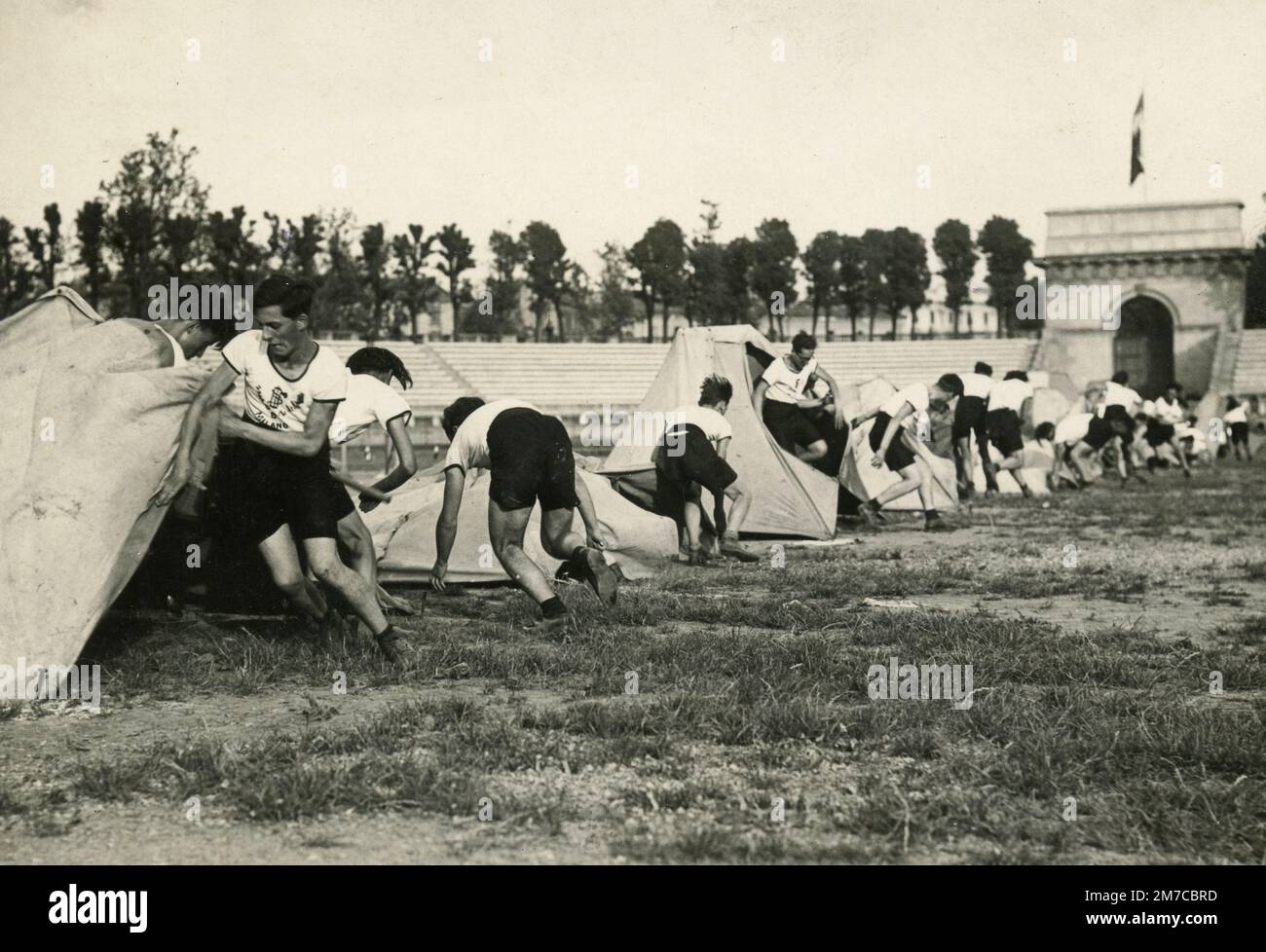 La squadra scolastica di Milano che mette le tende allo Stadio Civico durante la dimostrazione ginnica Premio Dux, Italia 1930s Foto Stock