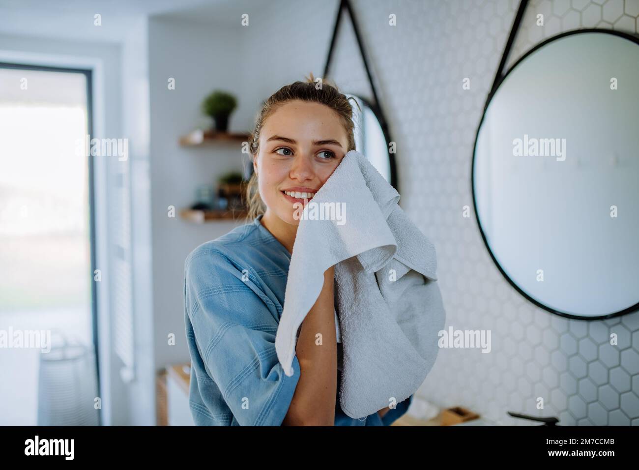 Giovane donna che si prende cura della sua pelle, mattina bellezza routine concetto. Foto Stock
