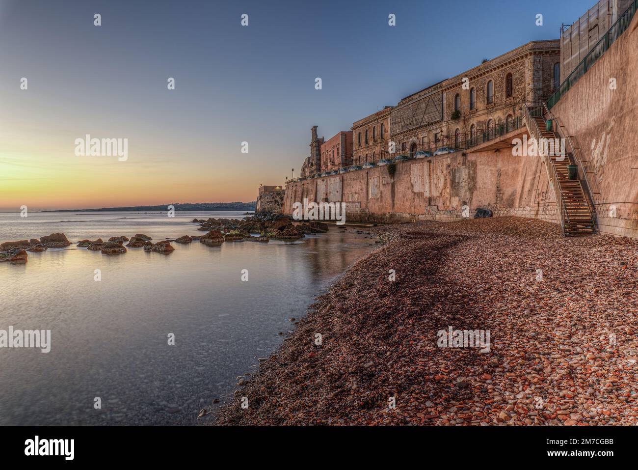 Il panorama mozzafiato del lungomare di Ortigia a Siracusa in Sicilia all'alba di un nuovo giorno Foto Stock