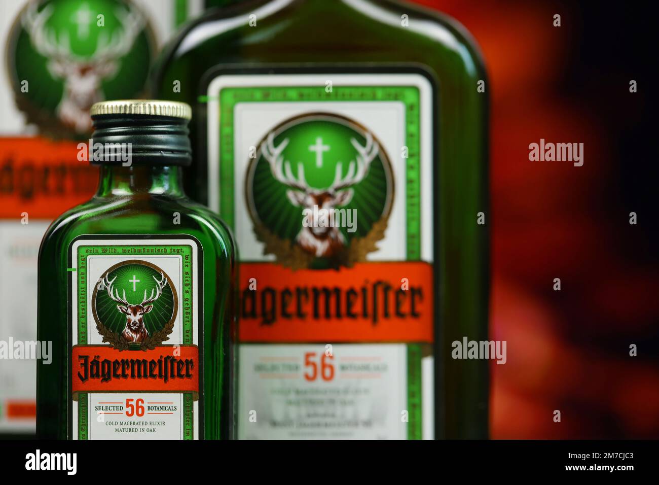 KIEV, UCRAINA - 4 MAGGIO 2022 Jagermeister bottiglia di alcol originale su tavolo di legno con camino rosso sullo sfondo. Produzione di alcool Elite Foto Stock