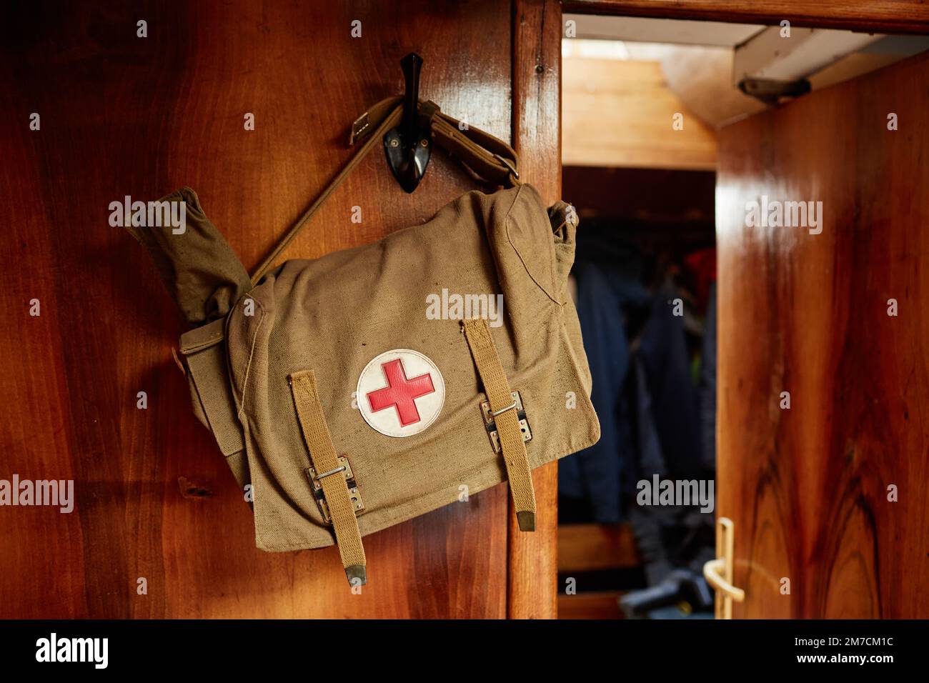 Primo piano del kit di pronto soccorso su una parete di legno all'interno di un treno o di uno yacht, spazio copia Foto Stock