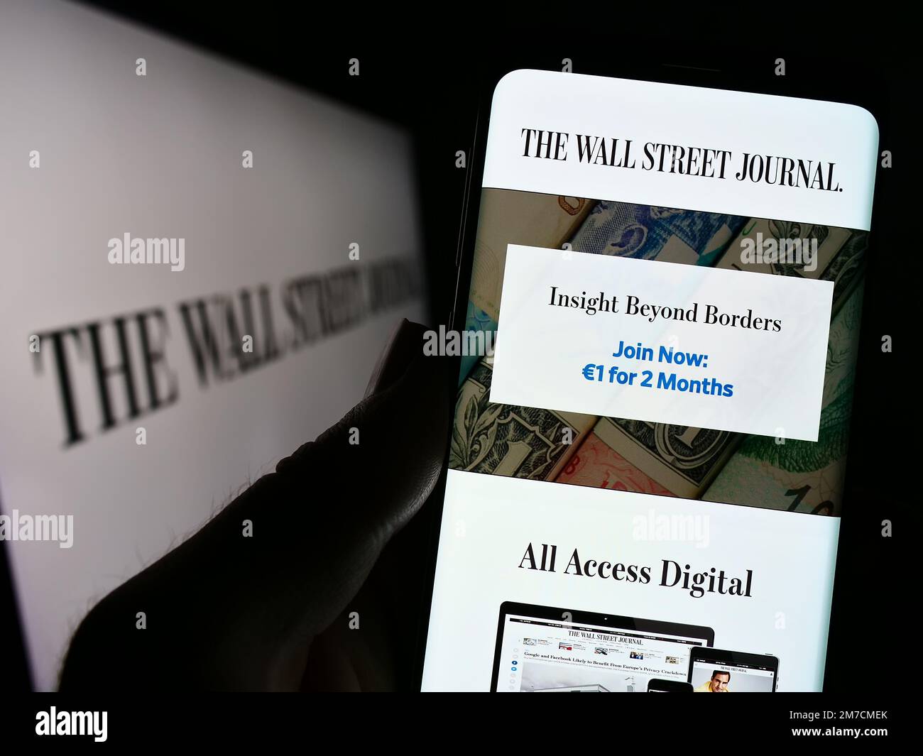 Persona che tiene il cellulare con il sito web del giornale americano The Wall Street Journal sullo schermo di fronte al logo. Messa a fuoco al centro del display del telefono. Foto Stock