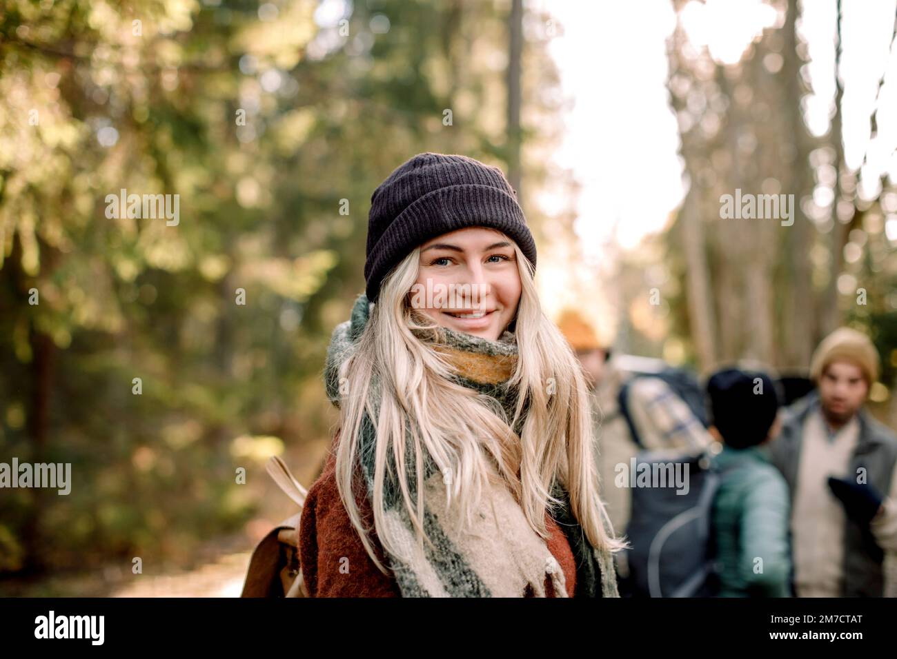 Vista laterale di una giovane donna sorridente con capelli biondi Foto Stock