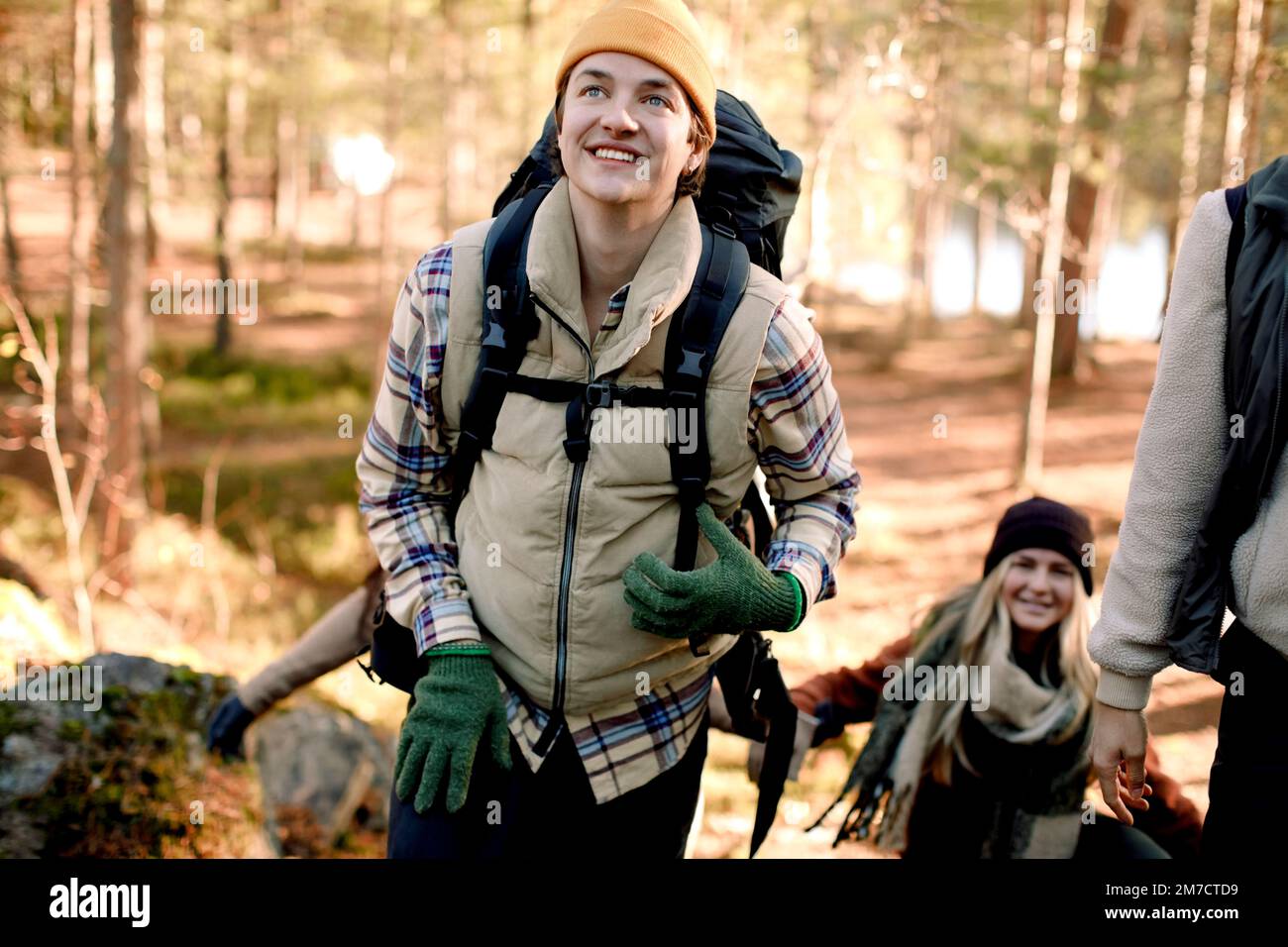 Felice uomo che guarda via mentre escursioni con gli amici nella foresta Foto Stock