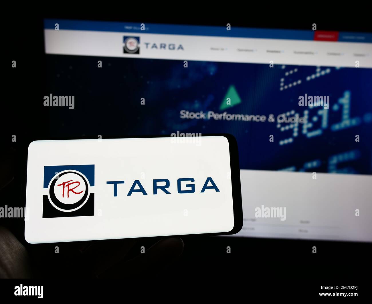 Persona che tiene il telefono mobile con il logo della società americana di energia Targa Resources Corp. Sullo schermo di fronte alla pagina web. Messa a fuoco sul display del telefono. Foto Stock