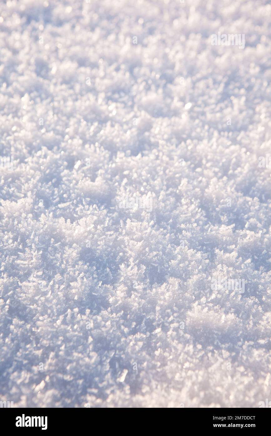 Neve si trova sulla campagna adn crea modelli astratti come esso riflette la luce dalle sue forme di cristallinità visto in rilievo. Foto Stock