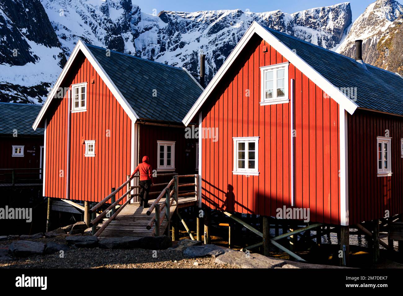 Una persona che ammira le tradizionali cabine di legno dei pescatori, Reine, Nordland County, Lofoten Islands, Norway Foto Stock