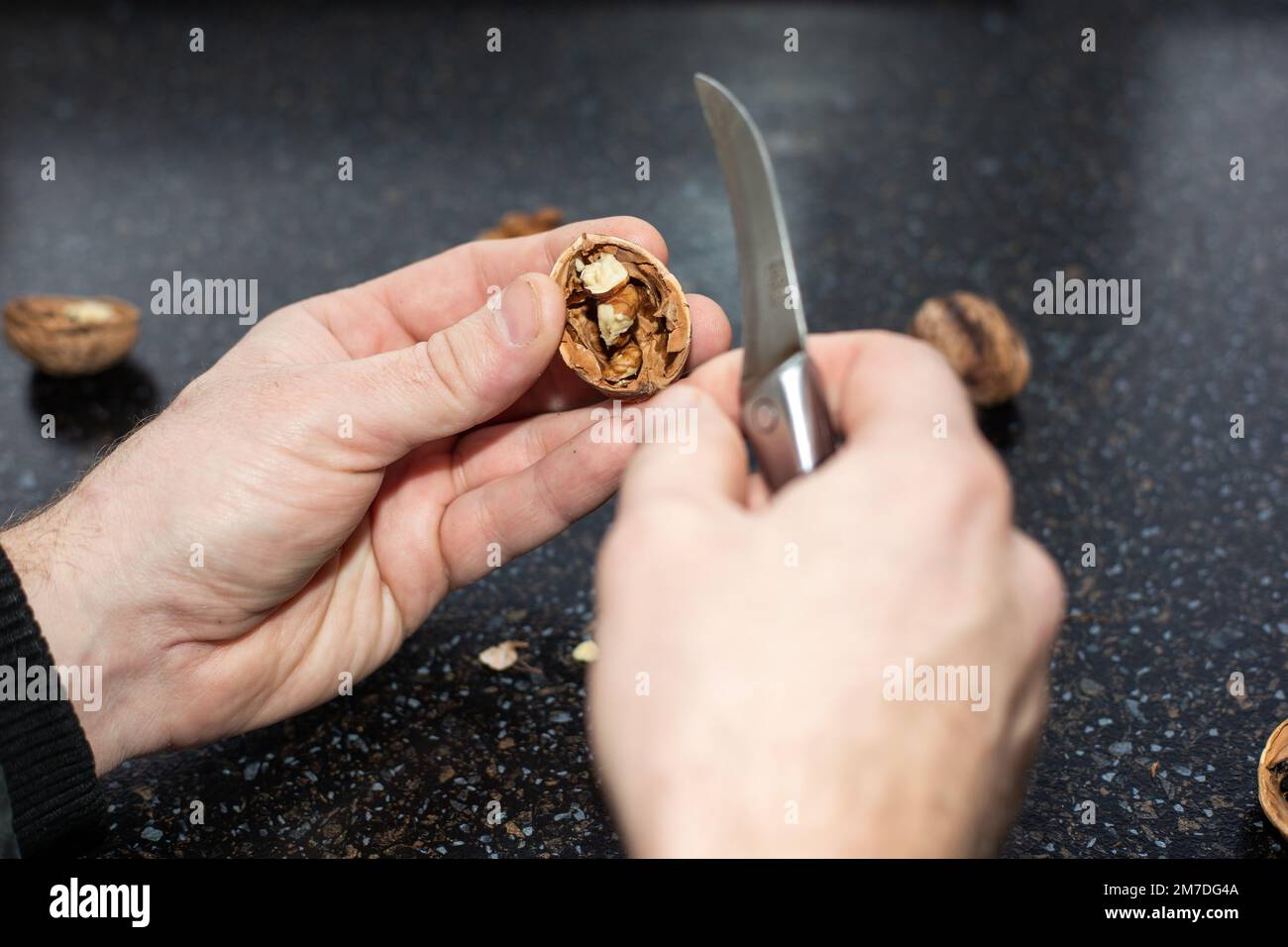 Un uomo ha sbucciato una noce con deliziosa frutta fresca. Foto Stock