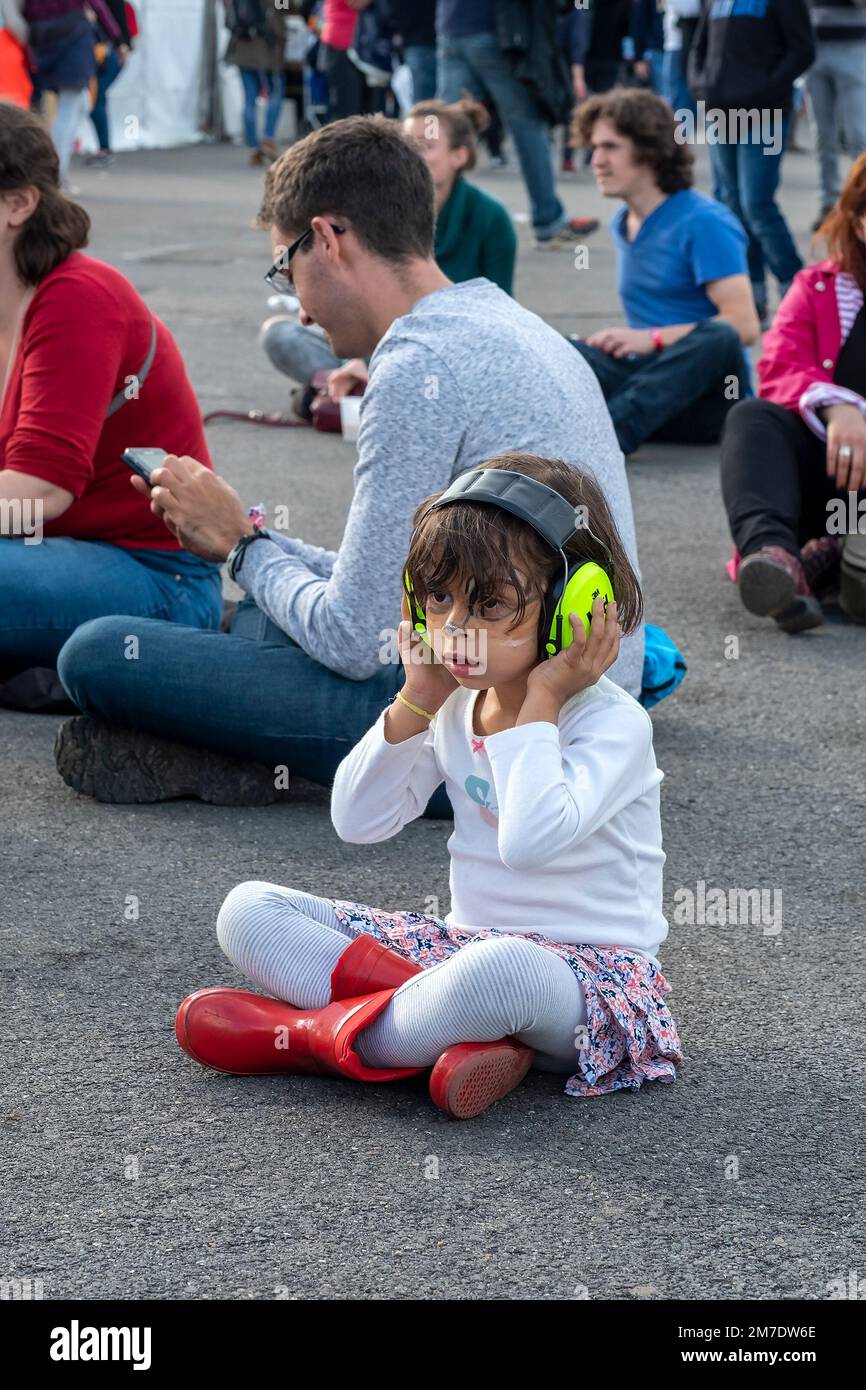 Bambina ad un concerto rock con cuffie per proteggere i suoi timpani Foto Stock