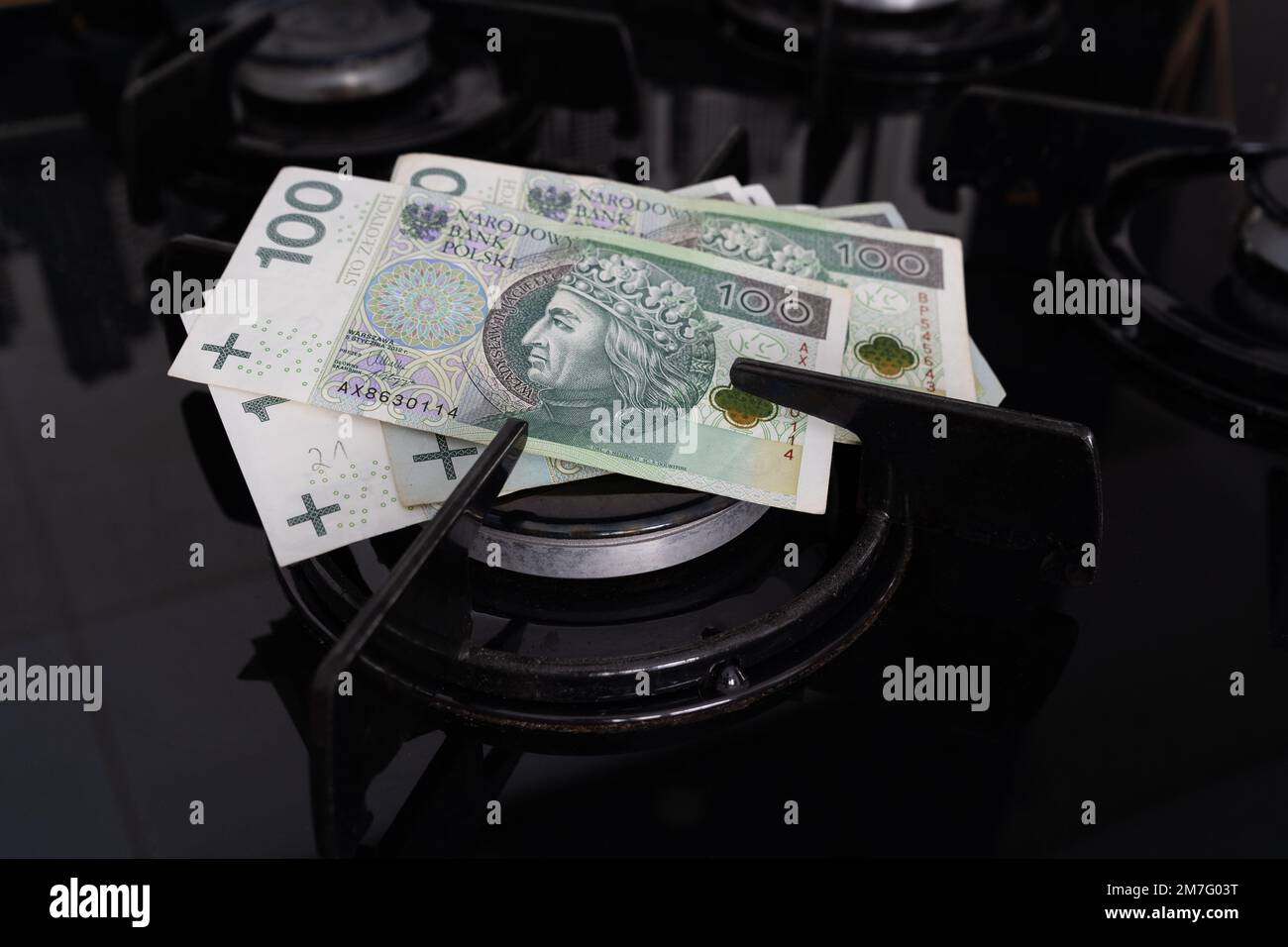 Banconote polacche zloty su un bruciatore di stufa a gas. Concetto di crisi energetica. Costo elevato di gas naturale. Aumento del prezzo del gas in Polonia e nel resto d'Europa. Foto Stock